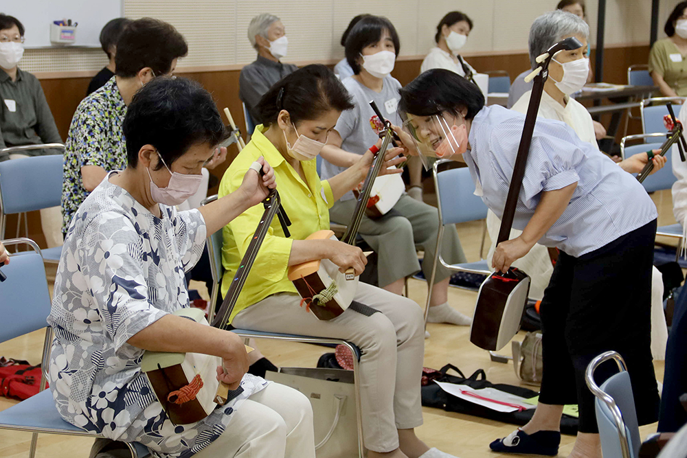 三味線の弾き方を一人ずつ教わる様子